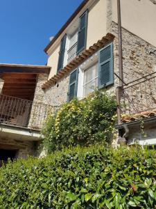 a building with a hedge in front of a building at CamElia in Garlenda