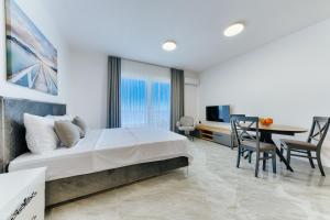 a bedroom with a large bed and a dining room at ARA Lux Apartments in Utjeha +113 photos