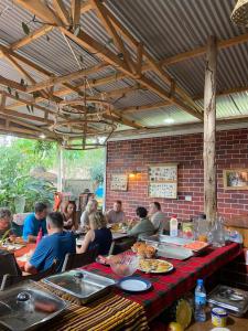 a group of people sitting at a table in a restaurant at Charming Eco-Homestay near Kilimanjaro International Airport in Arusha