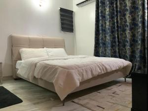 a bedroom with a bed with a white bedspread at La MAISON SEONE SILVER in Abidjan