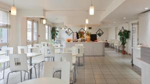 a restaurant with white tables and white chairs at Première Classe Rosny Sous Bois in Rosny-sous-Bois