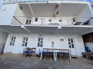 a building with a balcony and tables and chairs at Apartmani Vista Čanj in Čanj