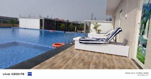 a swimming pool with a chair next to a building at White Coastal Beach Resort in Mandarmoni