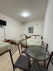 a room with two beds and a table and chairs at Apartmani Vista Čanj in Čanj