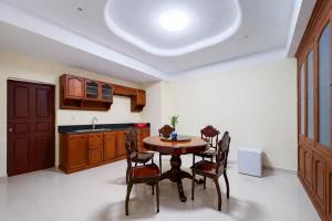 a kitchen with a table and chairs and a sink at Dara Express Inn by Angkor Green Gardens in Phumĭ Thnál