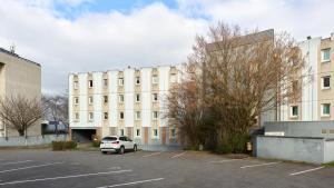 a car parked in a parking lot in front of a building at Première Classe Rosny Sous Bois in Rosny-sous-Bois