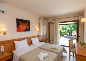 a hotel room with two beds and a window at Cave Luxury Villas Skiathos in Troulos