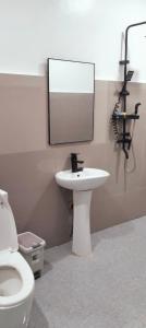 a bathroom with a toilet and a sink and a mirror at Safe Haven Residence in Talibon