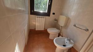 a small bathroom with a toilet and a sink at Functional and equipped apartment in Rosolina in Rosolina Mare