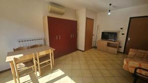 a living room with a table and a television at Functional and equipped apartment in Rosolina in Rosolina Mare