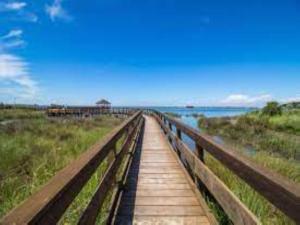 a wooden boardwalk leading to the ocean on the beach at Functional and equipped apartment in Rosolina in Rosolina Mare