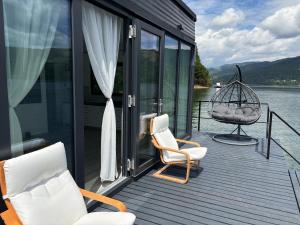 a house with two chairs and a swing on a deck at Black Swan Lakehouse in Bicaz