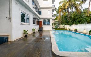 a swimming pool in front of a house at Cana Boutique Stay in Porvorim