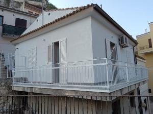 a white house with a balcony on top of a fence at La casetta Bianca in Modica
