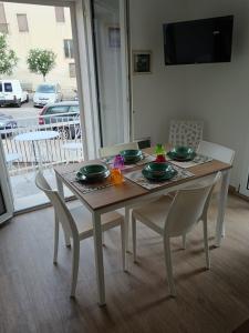 a table and chairs with plates and bowls on it at La casetta Bianca in Modica