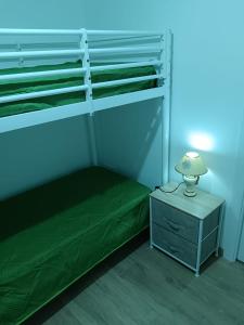 a bedroom with a bunk bed and a nightstand with a lamp at La casetta Bianca in Modica