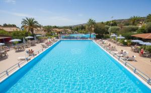 a pool at a resort with chairs and umbrellas at Villaggio Hotel Club La Pace in Tropea