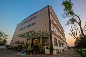 a large building with plants in front of it at Hotel Sravasti Residency in Katra