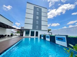 a swimming pool in front of a building at Remas Hotel Hat Yai in Ban Tha Thon