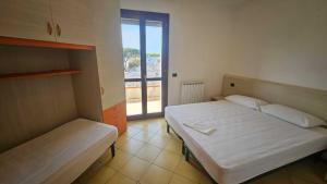 a bedroom with two beds and a large window at Familiar apartment with terrace in Rosolina in Rosolina Mare