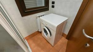 a washer and dryer in a small bathroom at Familiar apartment with terrace in Rosolina in Rosolina Mare