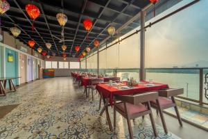 a restaurant with red tables and chairs and a large window at Lakeside Leisure A Lake View Hotel in Udaipur