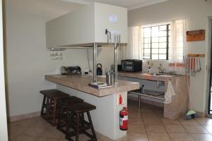 a kitchen with a counter and some stools in it at Kruger Bush Retreat in Marloth Park