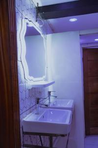 a white bathroom with two sinks and a mirror at Complexe Smile & Be in Yaoundé +48 photos