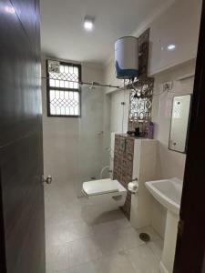 a bathroom with a toilet and a sink at Sarla Residency in Noida