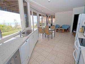 a kitchen with a counter and a table and chairs at Pelicans Perch in Lake Tyers