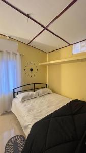 a bedroom with a bed with a clock on the wall at Niroda homestay in Jorhat