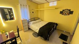 a bedroom with a bed in a yellow room at Niroda homestay in Jorhat
