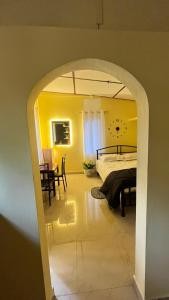 an archway into a bedroom with a bed and a table at Niroda homestay in Jorhat