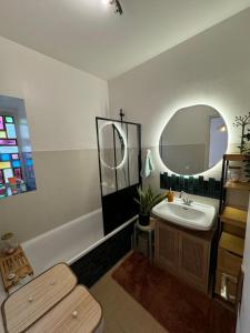 a bathroom with a sink and a mirror and a tub at T2 cosy - proche centre et plage in Quiberon