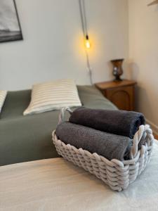 a basket of towels sitting on a table next to a bed at T2 cosy - proche centre et plage in Quiberon