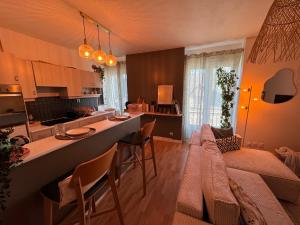a kitchen and living room with a couch and a table at T2 cosy - proche centre et plage in Quiberon