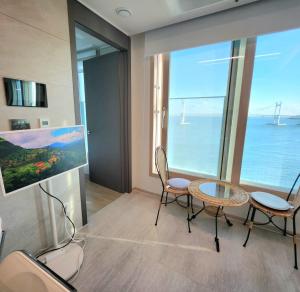 a room with a table and chairs and a large window at Busan#Gwanganli#Hot place#Healing Home in Busan
