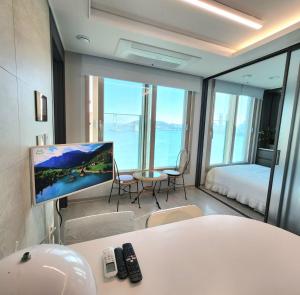 a room with a tv and a bed and a table at Busan#Gwanganli#Hot place#Healing Home in Busan