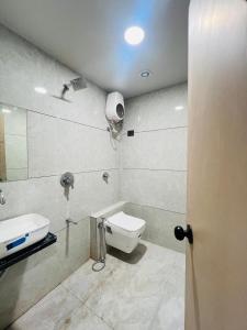 a bathroom with a toilet and a sink at Hotel Sulin Prahladnagar in Ahmedabad