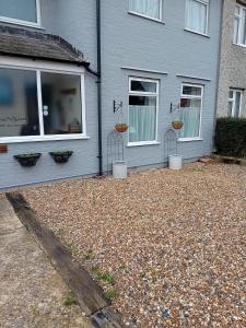 a gray house with two windows and two baskets at Owls Roost in Stowmarket