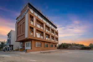 a large building with a clock on top of it at Lakeside Leisure A Lake View Hotel in Udaipur