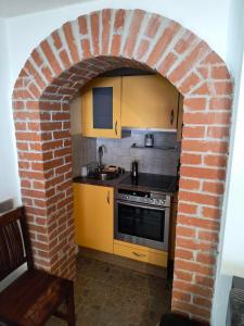a kitchen with a brick archway with a sink and a stove at Ferienwohnung Naturglück in Sellrain