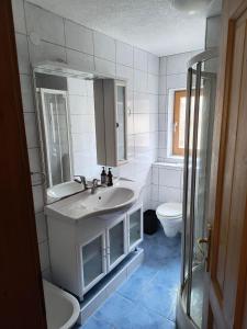 a white bathroom with a sink and a toilet at Ferienwohnung Naturglück in Sellrain +10 photos