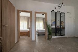 a room with two mirrors and a bedroom with a bed at Aura Residence Beachfront by Horizon Homes in Ofrínion