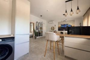 a kitchen with a counter with a washer and dryer at Aura Residence Beachfront by Horizon Homes in Ofrínion