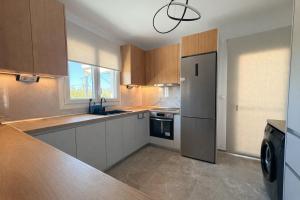 a kitchen with a refrigerator and a sink in it at Aura Residence Beachfront by Horizon Homes in Ofrínion
