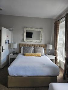 a bedroom with a large white bed with two night stands at Brogans Bar & Hotel in Trim +41 photos