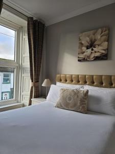 a bedroom with a large white bed with a window at Brogans Bar & Hotel in Trim
