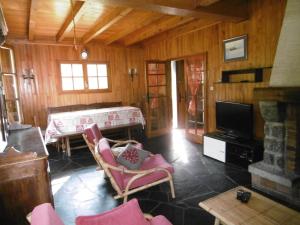 a living room with pink chairs and a television at Chalet de caractère in Alex