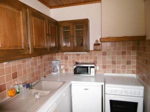 a kitchen with a sink and a microwave at Chalet de caractère in Alex +7 photos